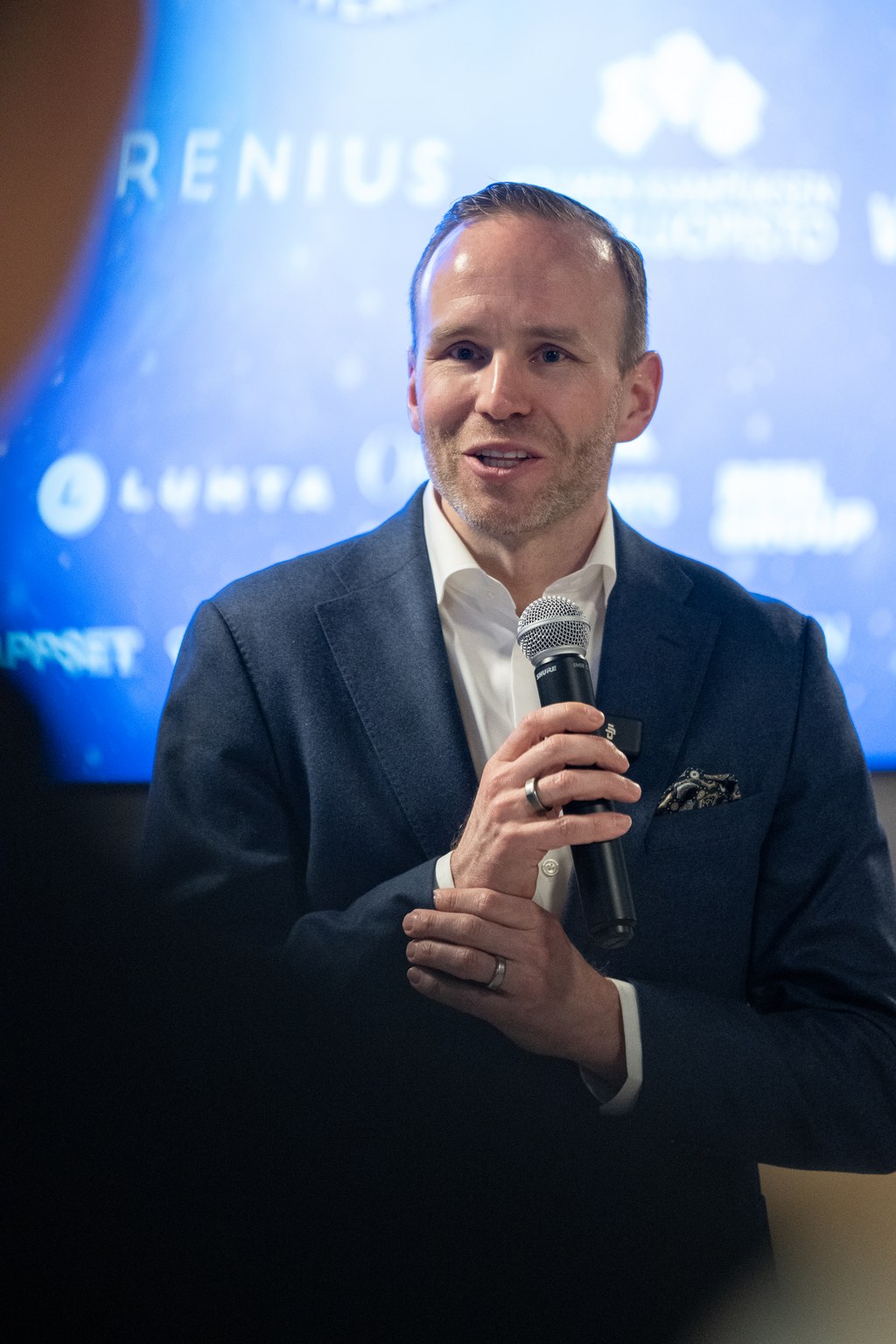 Mika Poutala puhumassa Pohjoisen tähdet -taustan edessä.